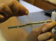 opening the whirlpac bag by pulling apart the tabs on the top